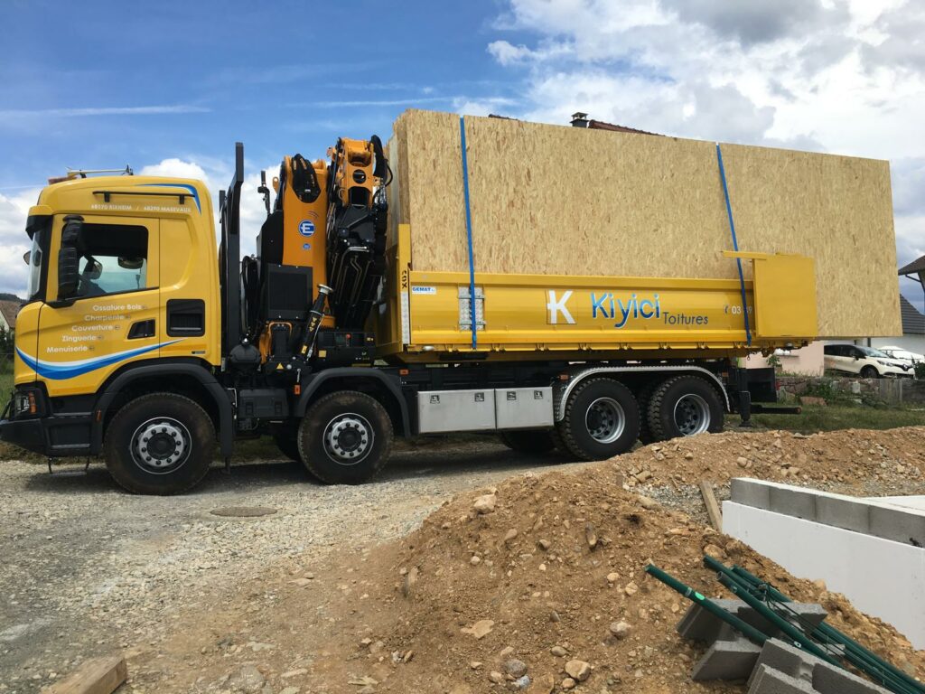 Camion grue chargé de panneaux d'ossature bois