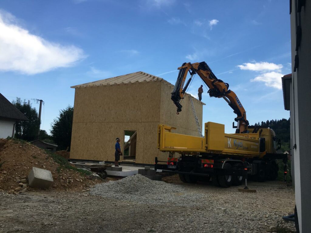 Camion grue de SASU BADI livrant une maison à ossature bois